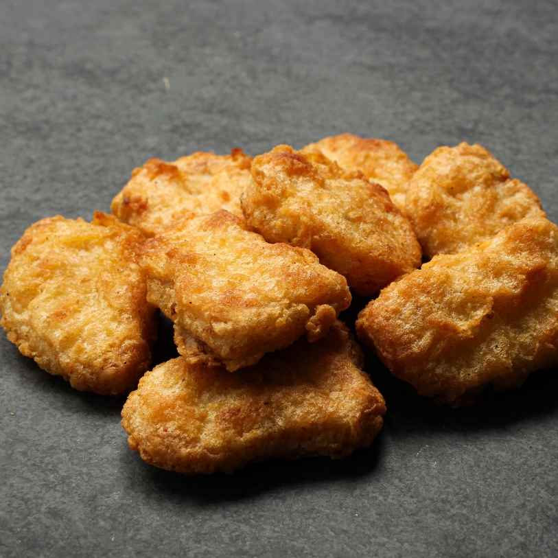 Overhead view of cooked Chicken Fritters on a black slate.