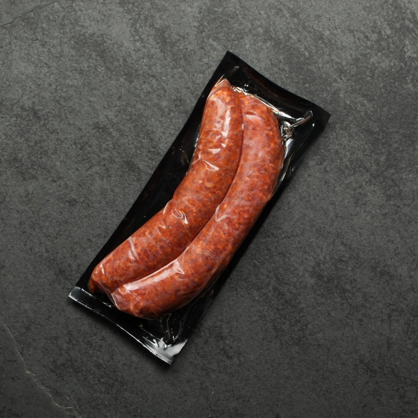 Overhead image of two vacuum packaged Iberico pork chorizo sausages.