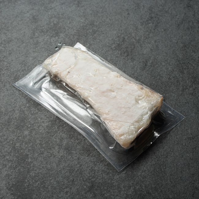 angled view of a vacuum-packaged piece of frozen Icelandic cod