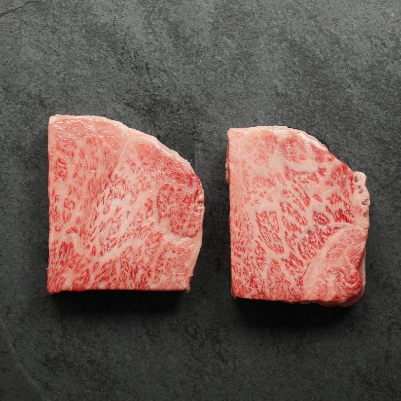 angled view of two raw Japanese A5 wagyu New York Steaks - California cut