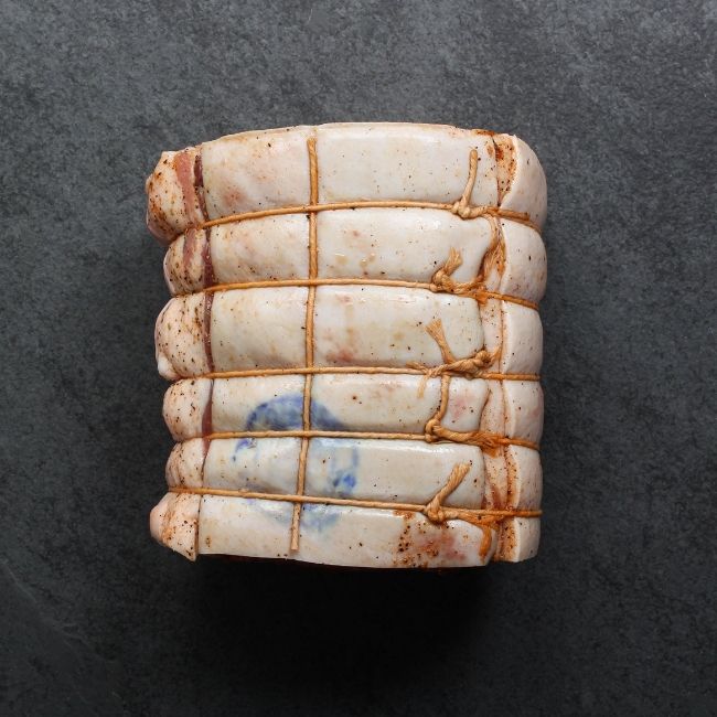overhead view of a raw, seasoned and tied porchetta roast