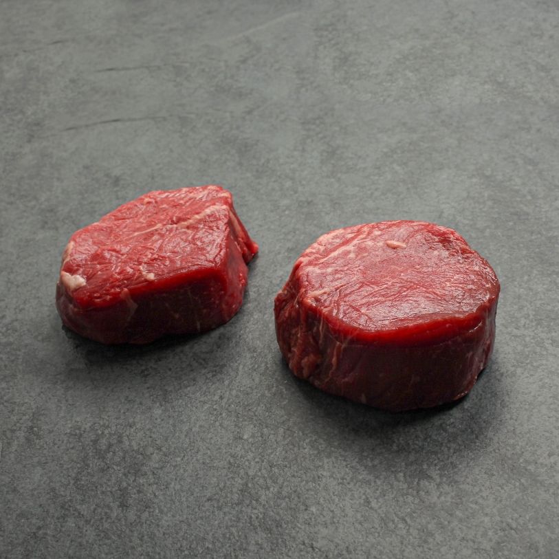 angled image of two raw beef filet mignon steaks