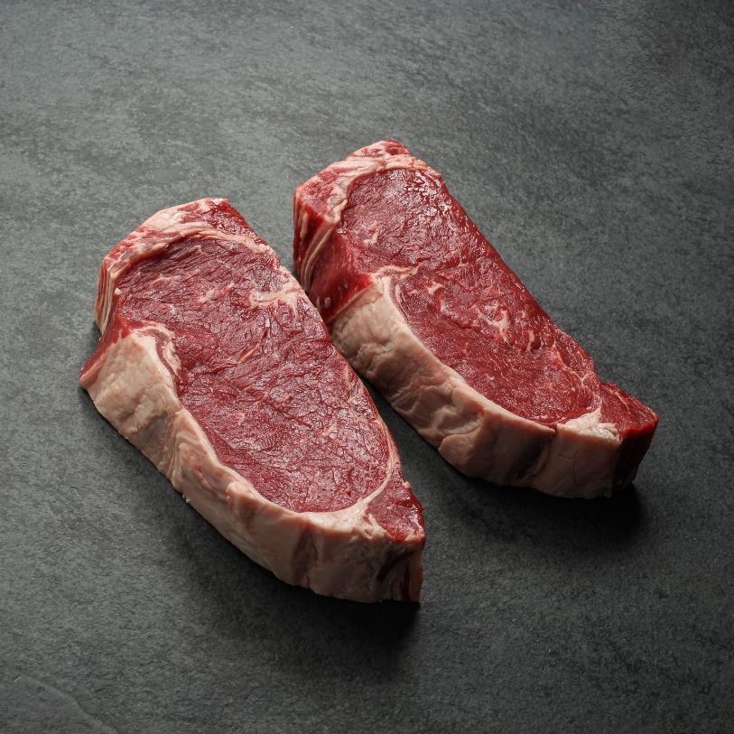 overhead view of two raw new york steaks