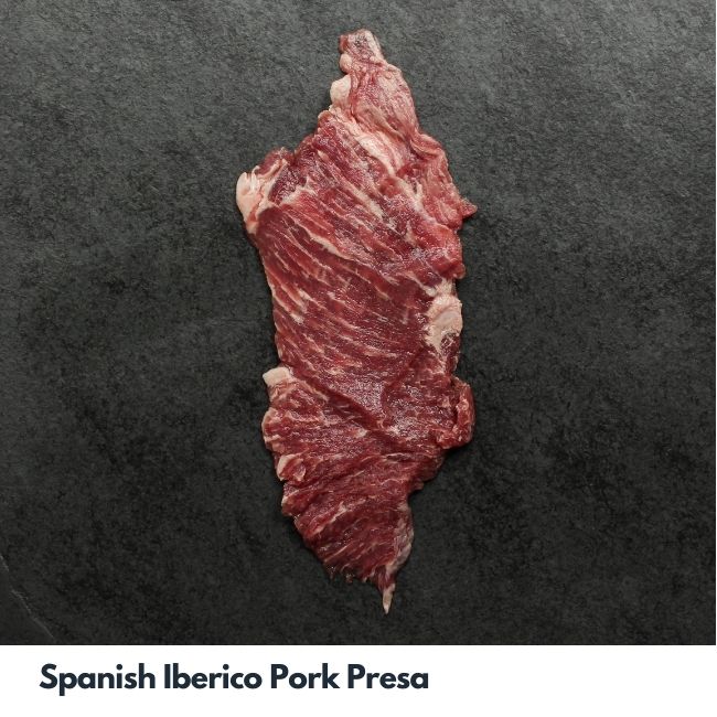 overhead image of a heavily-marbled, thinly-sliced raw cut of Spanish Iberico pork presa