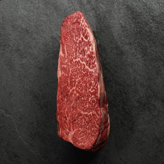 overhead view of the side of a richly marbled raw wagyu beef sirloin roast