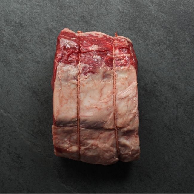 overhead view of a raw beef capless prime rib roast, with the backbone removed and tied back on
