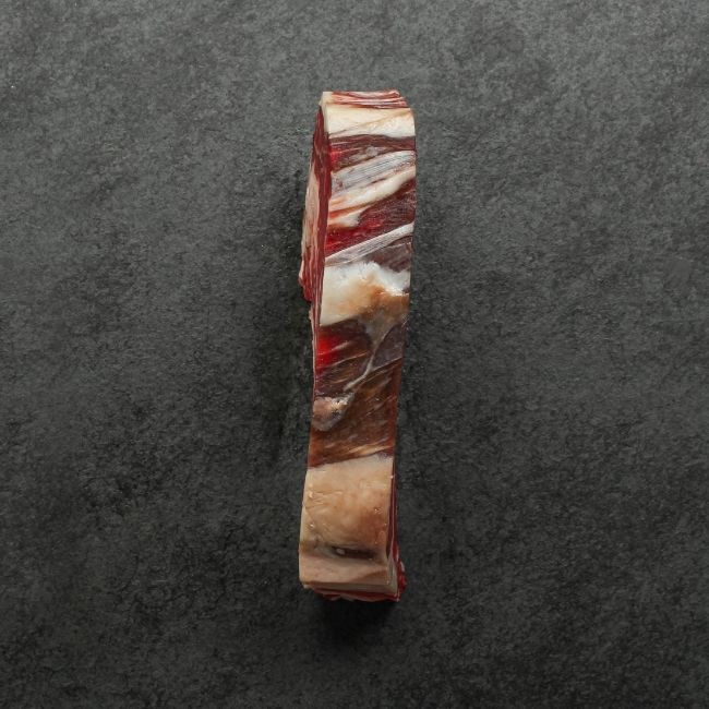 side view of a raw dry aged rib eye steak