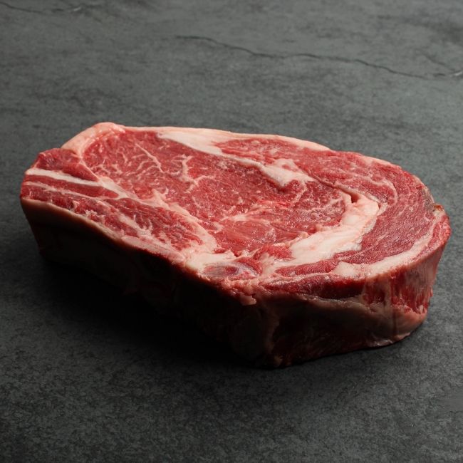 angled view of raw bone in rib steak.