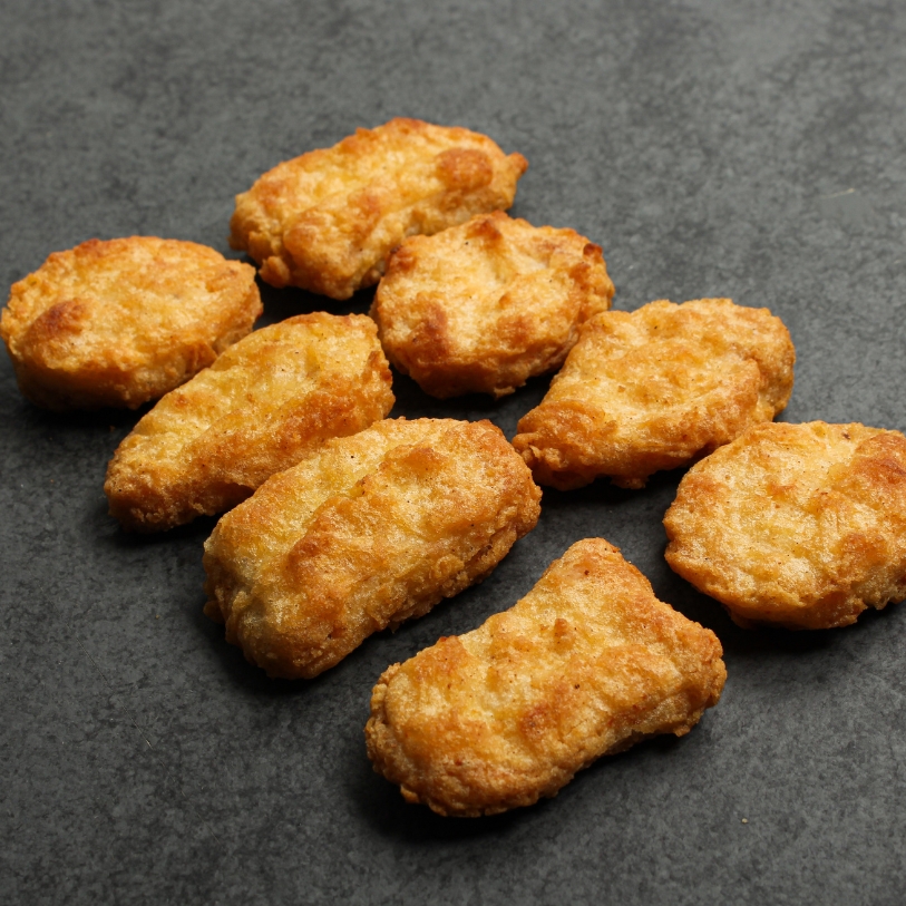 Overhead view of cooked Chicken Fritters on a black slate.