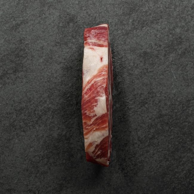 side view of heavily marbled iberico pork collar steak