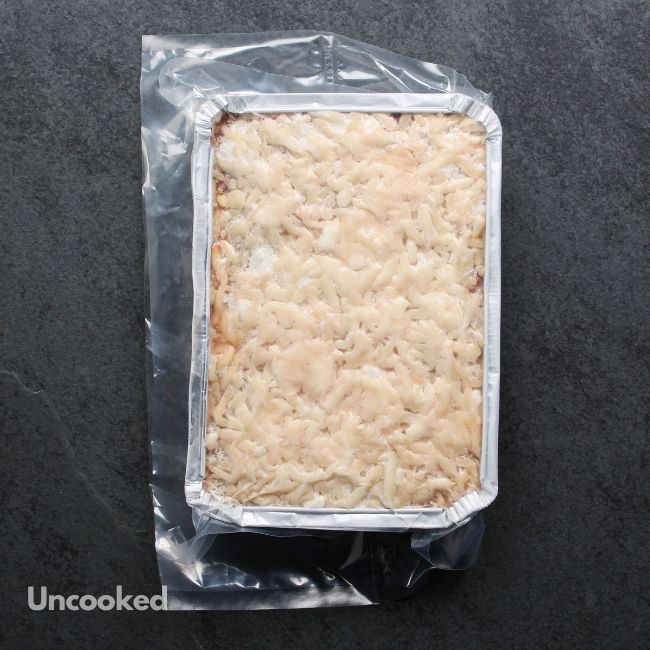 overhead view of an uncooked, cheesy lasagna