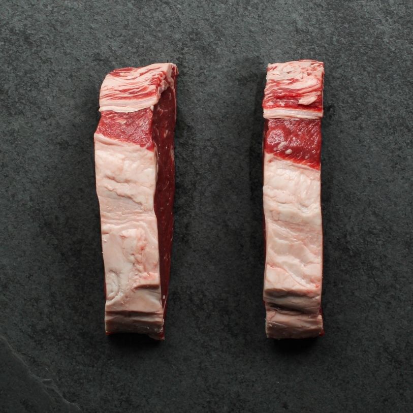 overhead view of the side of two raw new york steaks