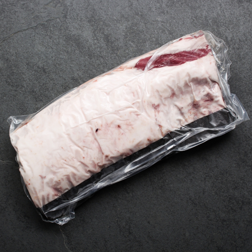 Overhead view of a whole Spanish Iberico Pork Rack in vacuum packaging.
