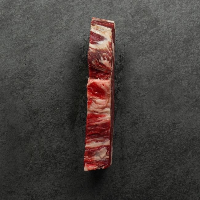 side view of a raw dry aged rib eye steak