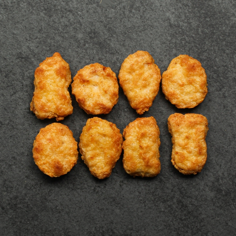 Overhead view of cooked Chicken Fritters on a black slate.