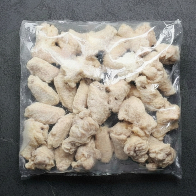 Overhead image of cooked chicken wings in a bag.
