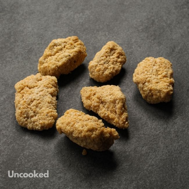 angled view of raw crispy breaded chicken bites