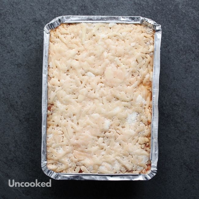 overhead view of an uncooked, cheesy lasagna in vacuum packaging