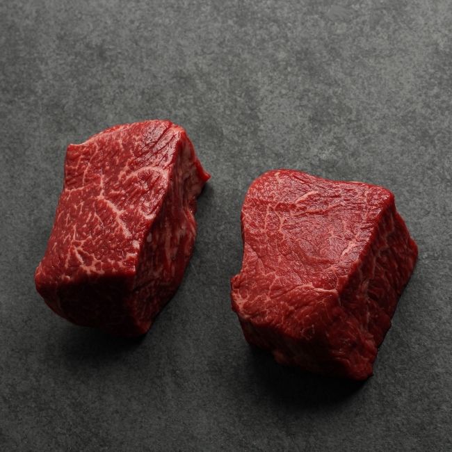 angled view of two well-marbled sirloin steaks