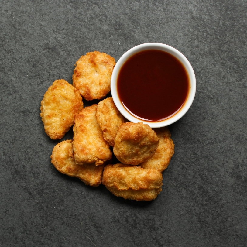Overhead view of cooked Chicken Fritters on a black slate.