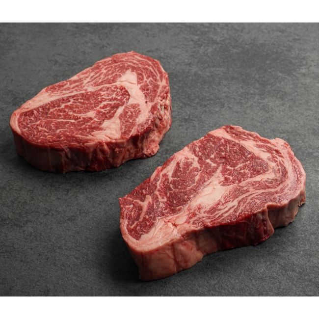 angled view of two heavily marbled Australian wagyu rib eye steak