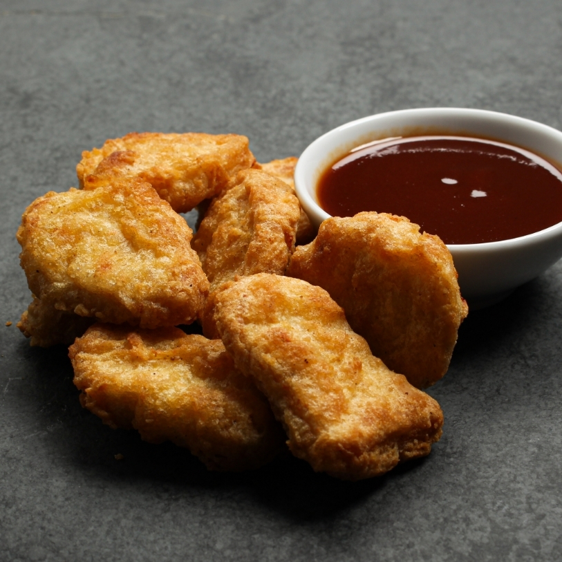 Overhead view of cooked Chicken Fritters on a black slate.